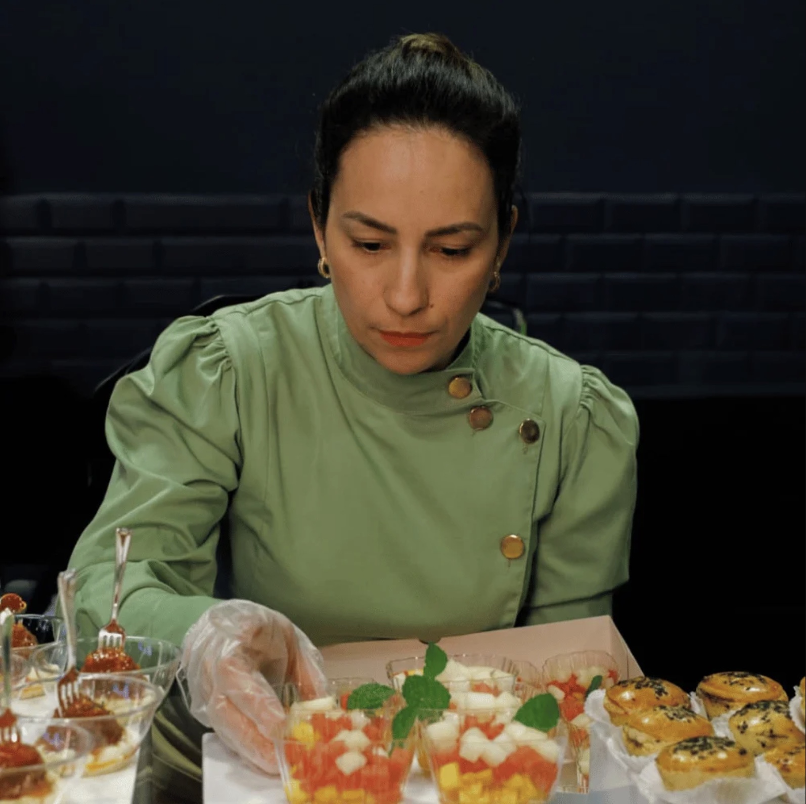Camila Souza preparando finger food na cozinha